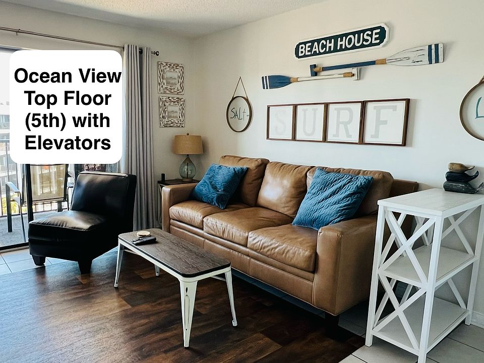 Main living area with large sliding doors, nice bright sunny space and large balcony looking at ocean.