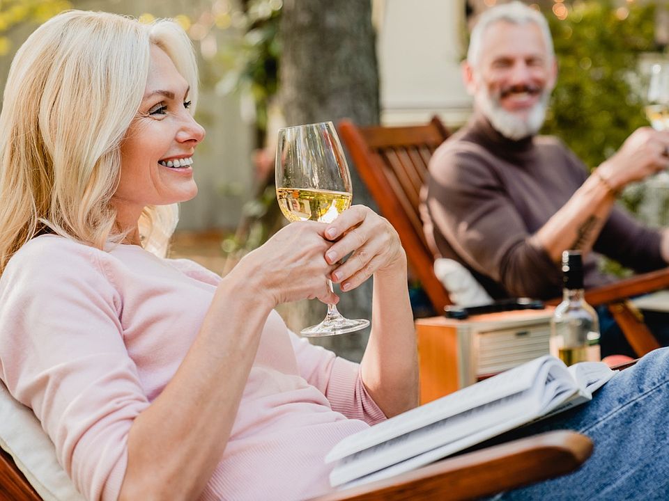 two people enjoying a glass of white wine outside