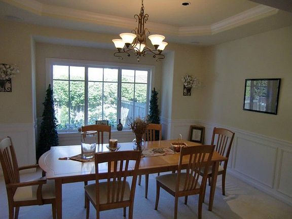 Elegance abounds in this dining room with coffered ceiling and wainscoting!