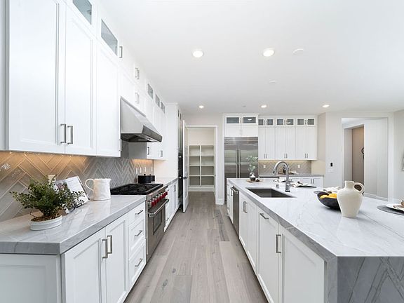 This image showcases the kitchen with staged furnishings in Villas Homesite 78.