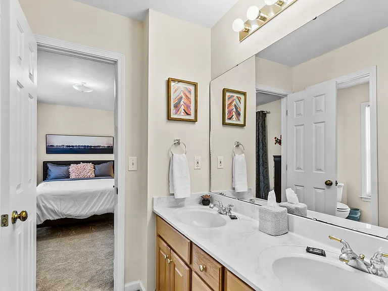 Jack and Jill style bathroom with dual vanities and full bathroom