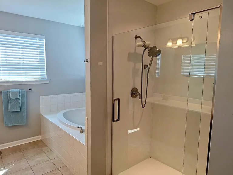 A bright, modern bathroom featuring a walk-in glass shower and ample space to start or end your day.