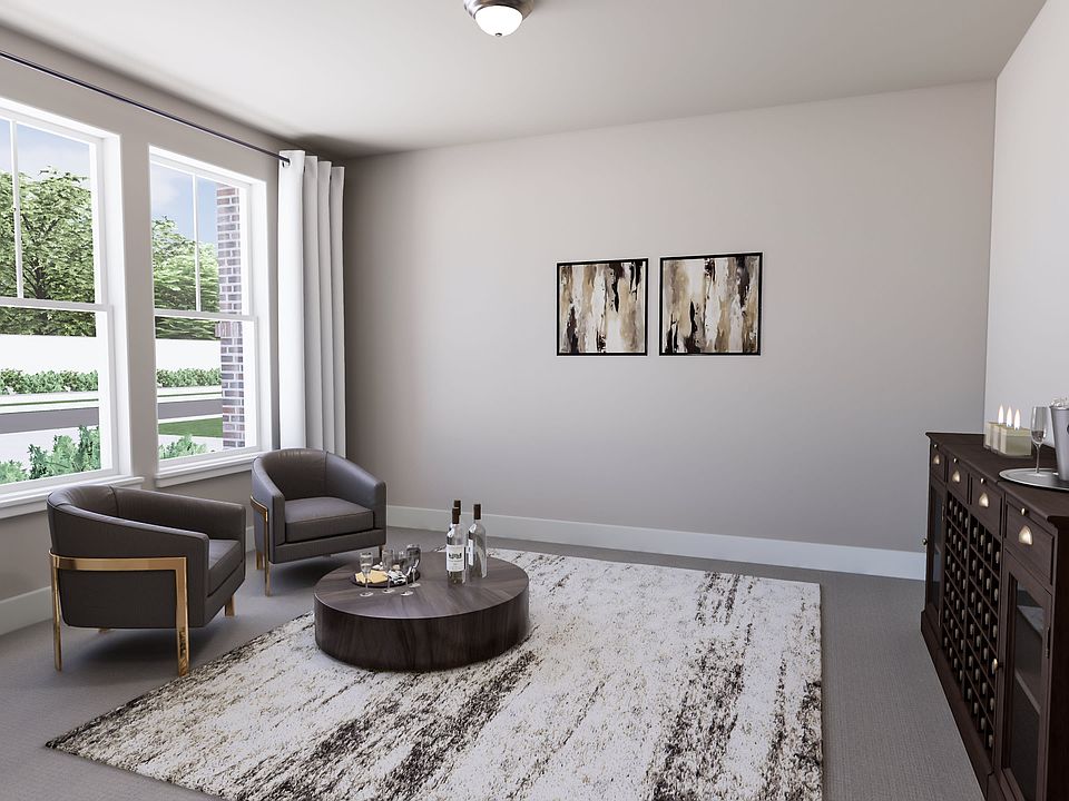 A cozy living room with a large window, a gray armchair, a round coffee table, and abstract artwork