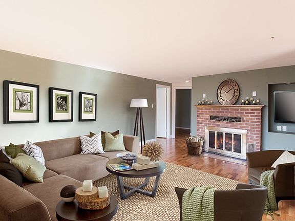 Living room features hardwood floors, brick fireplace and niche for your TV. This room has loads of windows that overlook the private lawn and gardens. 