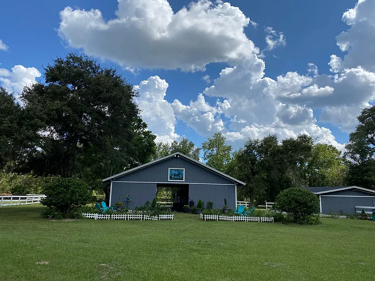 The big barn is the center aisle with 5 stalls, 1 feed room, 1 tac room, a hay mow, and bathroom with toilet and sink. There is a connection for a washer and dryer in the barn. All stalls have ceiling fans and a fly sprayer system. The front of the big ba