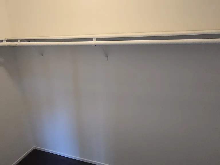 Walk-in closet with wrap around shelving and hanger rods