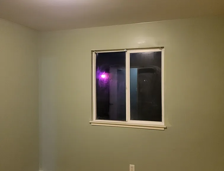 Bedroom after baseboards were installed and new luxury vinyl tile flooring