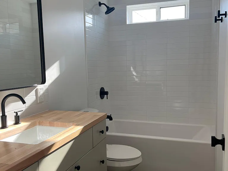 Bathroom with deep tub, chic fixture, vanity and butcher block counters