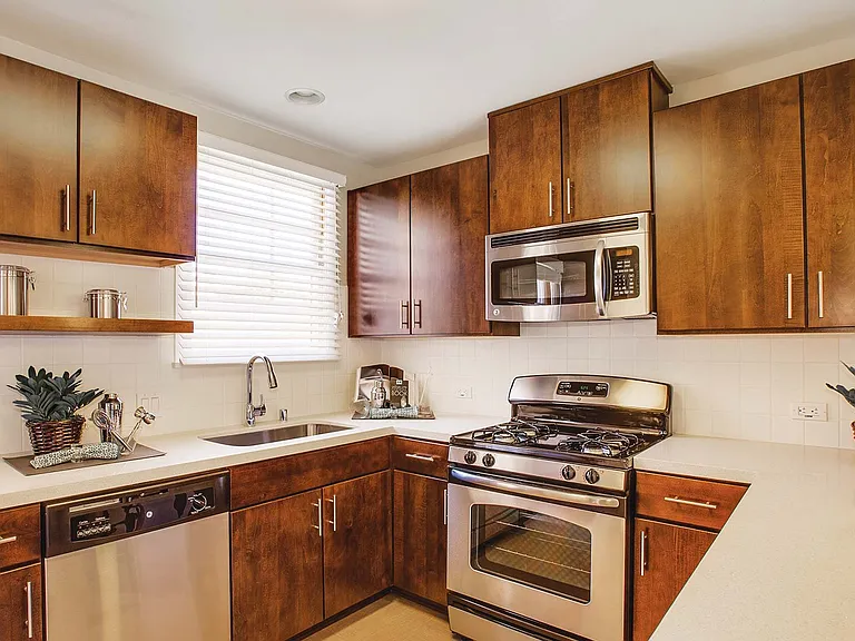 Renovated kitchens with stainless steel appliances, quartz countertops, and walnut cabinets