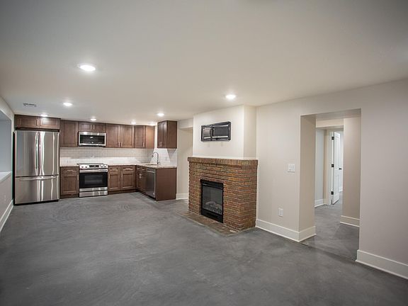 Living area with open concept kitchen and original 1920's fireplace with electric insert and TV wall mount ready to go.