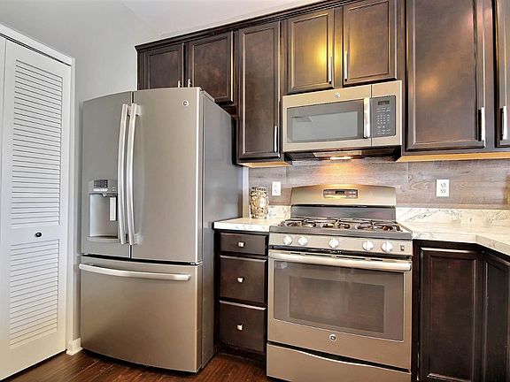 BEAUTIFUL AND WARM OPEN CONCEPT MFLOOR w/UPGRADED WOOD FLOORING, CABINETS, BREAKFAST BAR, STAINLESS STEEL APPLIANCES, LIGHTING, CARPET & MORE!