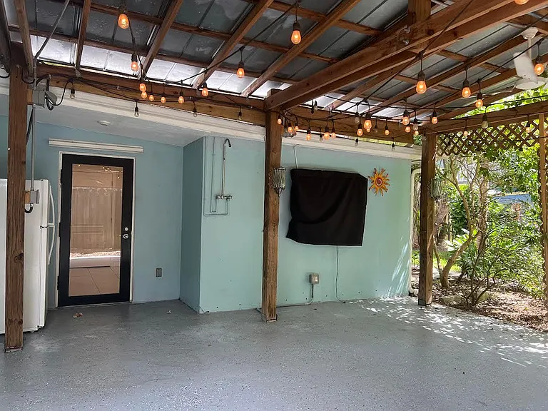 Outdoor television entertainment area with a shower and refrigerator.