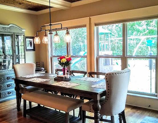 Eating area off kitchen features hardwood floors and lots of windows.