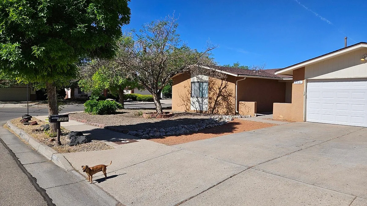 Two car garage, front welcoming porch, drive way parking and side yard access. - 7201 Pecos Trl NW