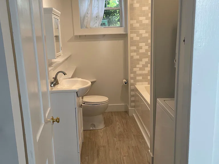 Recently updated bathroom with new floors and tiles shower/tub.