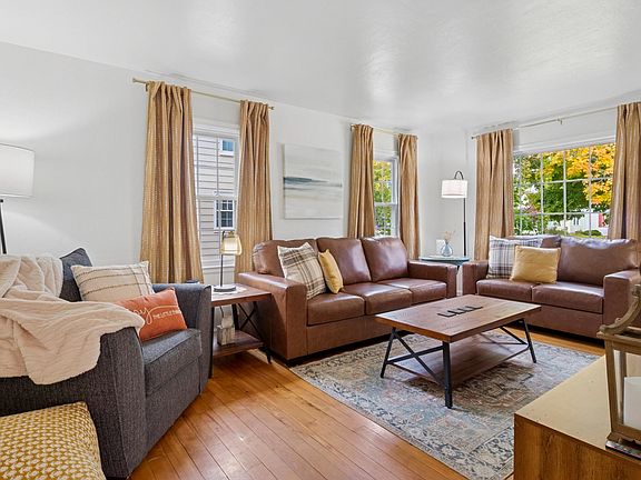 Settle in and stream in style_our South Bend living room features a 65" smart TV, plush seating, accent tables with built-in chargers, and cozy throws and pillows for lounging near Notre Dame.
