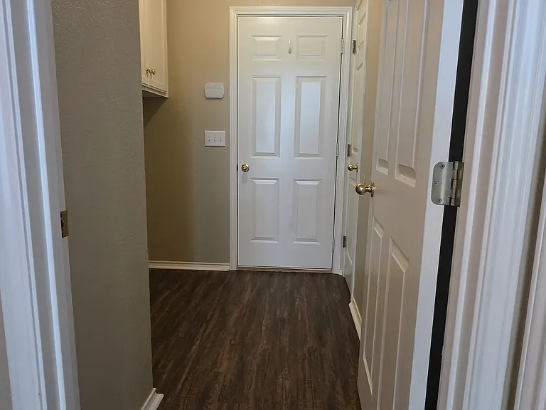 LAUNDRY ROOM WITH CABINETS AND CLOSET ON THE RIGHT. STRAIGHT AHEAD TO GARAGE