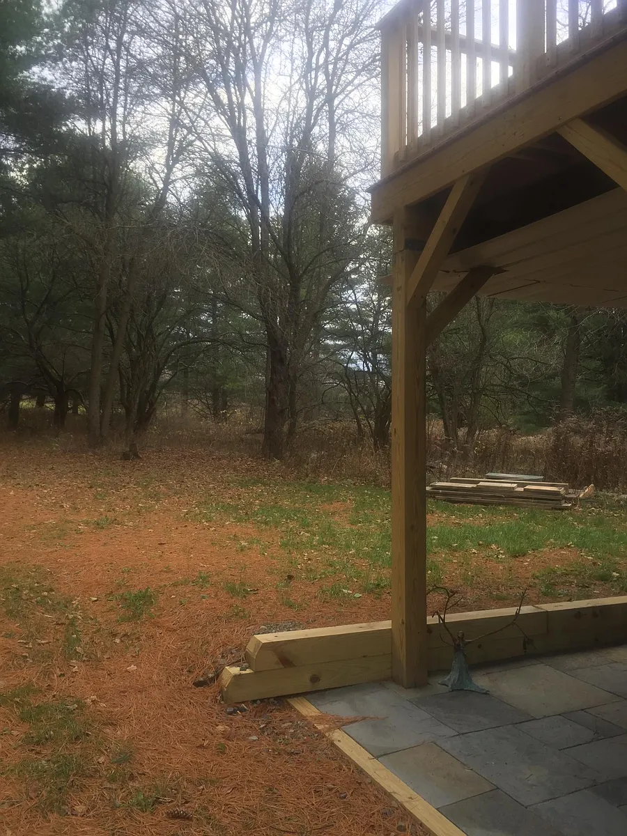view of private yard from stone patio with deck above. - 100 Gunderman Rd