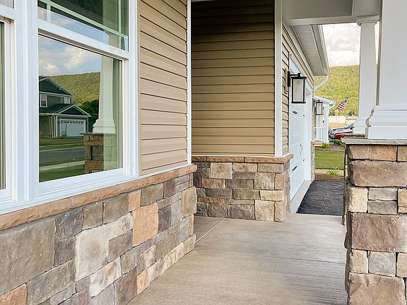 Front porch with partial stone kneewall and stone pillars