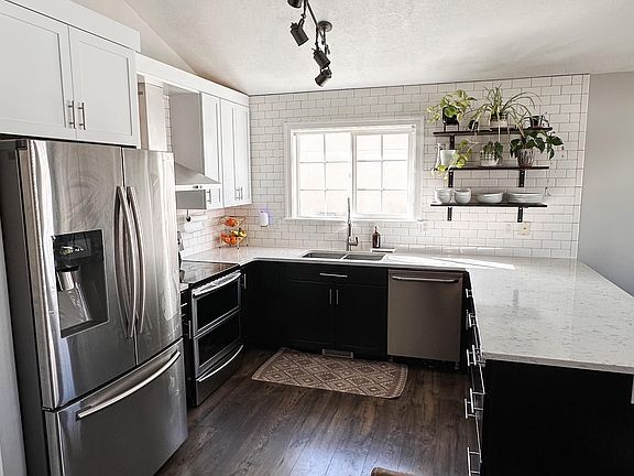 This sleek, modern kitchen comes fully equipped with a fridge, microwave, dishwasher, and oven. With clean lines, ample counter space, and stylish finishes, it's perfect for cooking and entertaining.
