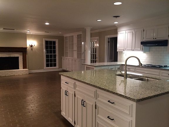 Open Concept kitchen and family area : Wood burning fireplace with door leading to private covered p