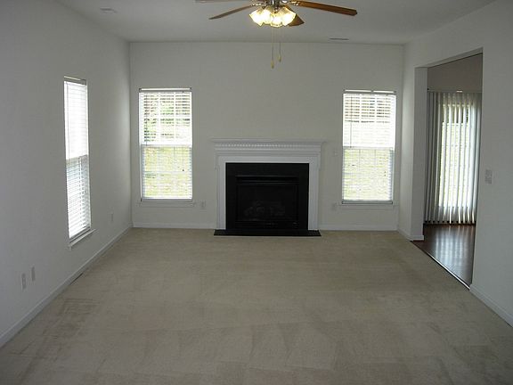 Living Room with a gas fireplace, neutral rug & ceiling lite/fan
