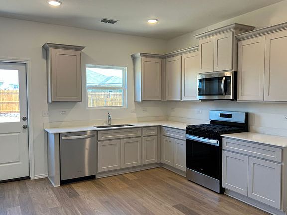 Interior living offers open kitchen with access to backyard photo depicts features that may vary