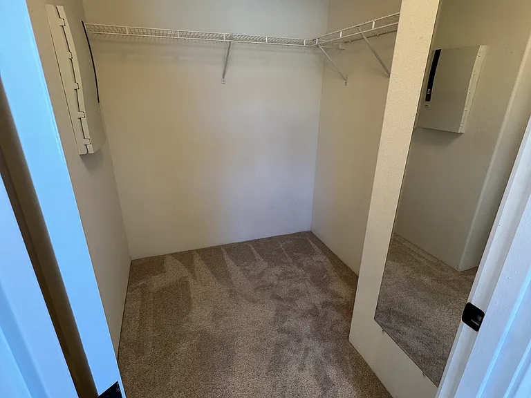 Master bedroom walk in closet. There's more closet space behind the door.