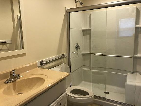 Bathroom with step in shower and place to sit.