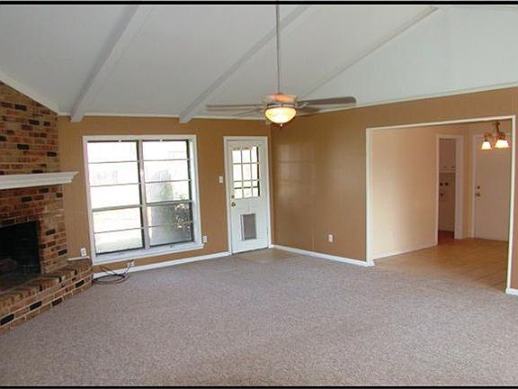 LOOKING FROM THE FRONT DOOR AT FAMILY ROOM SHOWING THE WALL OF WINDOWS AND CEILING FAN. OPENS INTO T