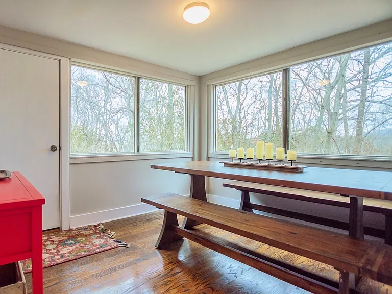 Sunroom dining room surrounded by windows and exit door to back yard