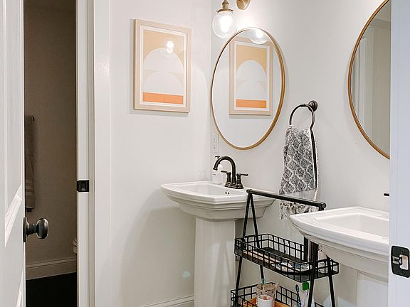 bathroom w/ two sinks + pocket door between sink area and shower/toilet area