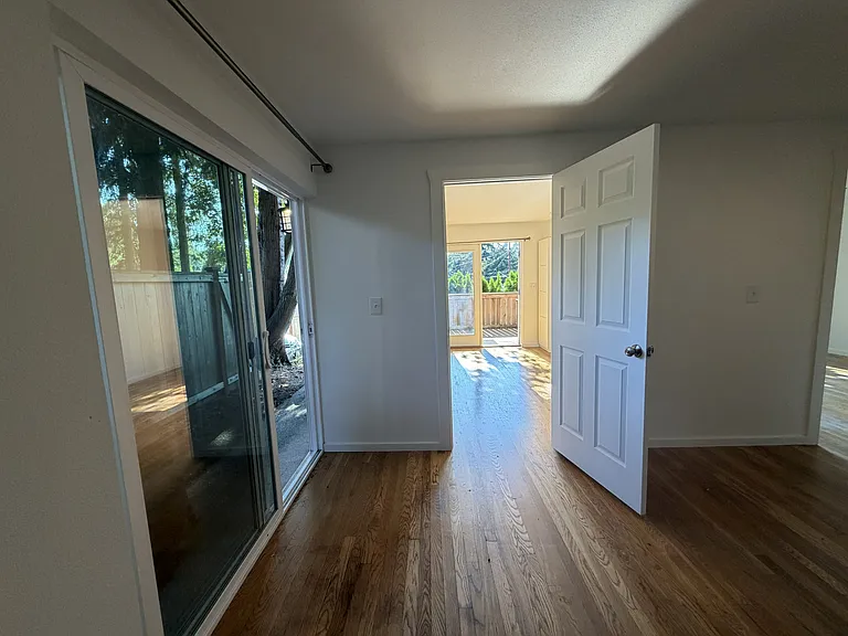 View of living room space off of kitchen. Notice nice sliding door in kitchen