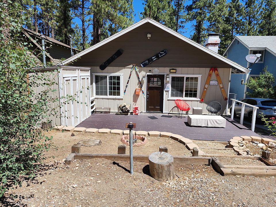 Front of house with off street parking and large deck in front.