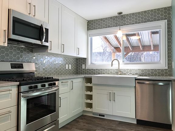 New kitchen with stainless appliances, quartz countertops.