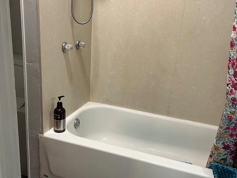 Full bathtub and shower combo with simple wall surround and easy-clean surfaces for everyday use.
