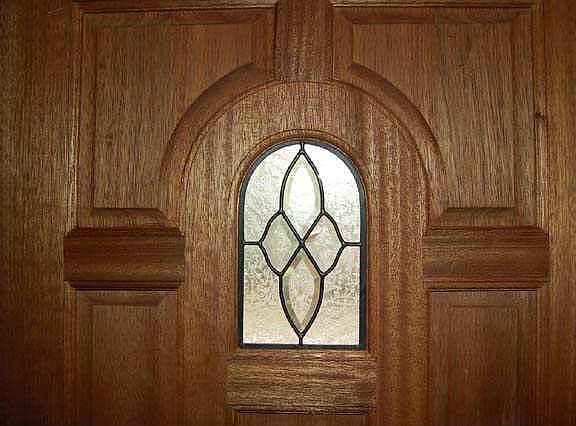 Mahogany front door with beveled glass details.