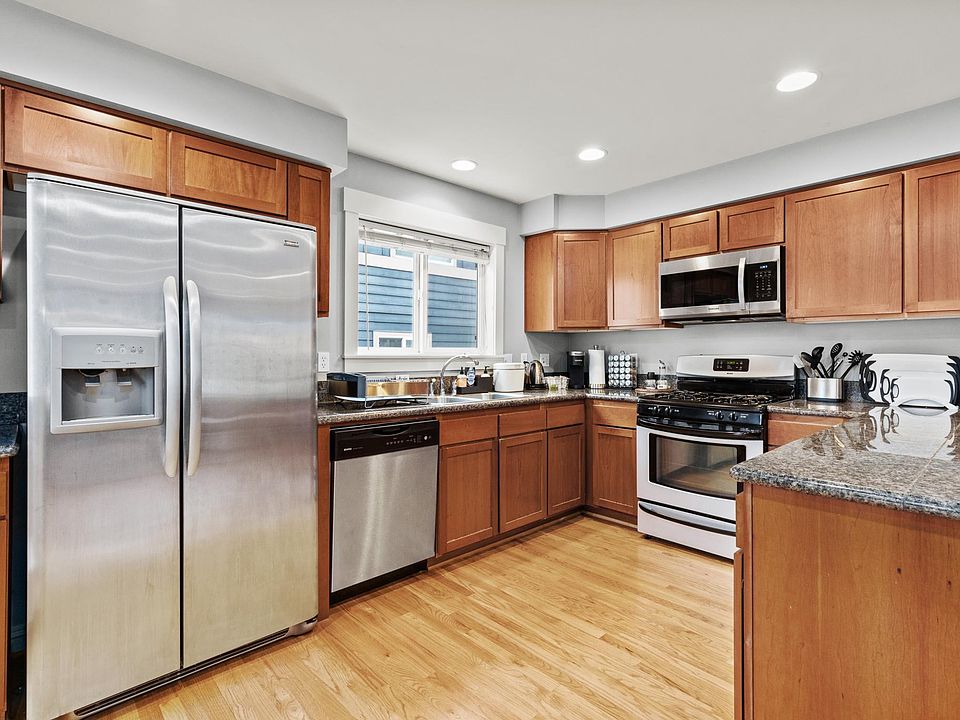 Open kitchen, dining, and living area on 2nd floor. Features covered balcony, half-bath, and gas fireplace. (Picture taken of another unit, same floor plan but mirror-imaged)