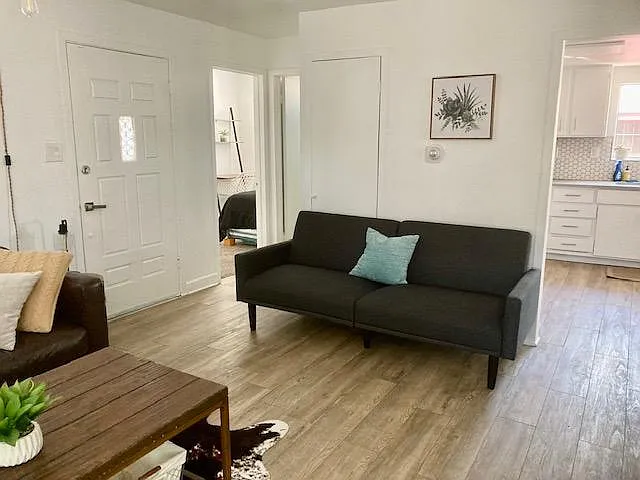 Entrance to kitchen from living, backdoor to private fenced patio (with bbq and outdoor lounge furniture), and another couch that folds into a futon for guests.