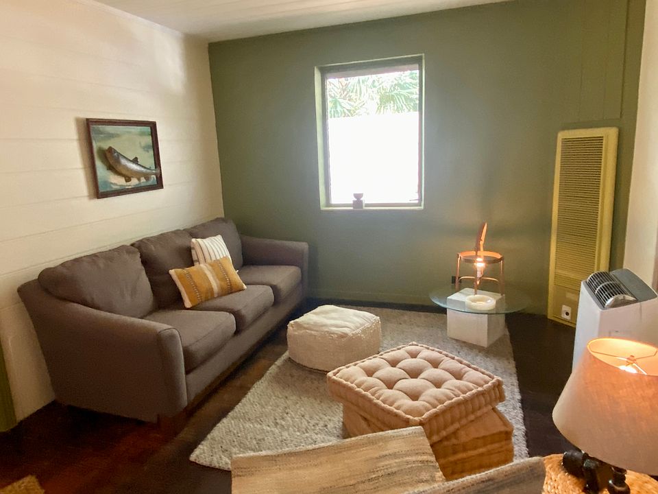Comfy living area with deep sofa, vintage fish art, pleasant light, soft area rugs, hardwood floors, and cool lighting fixtures __