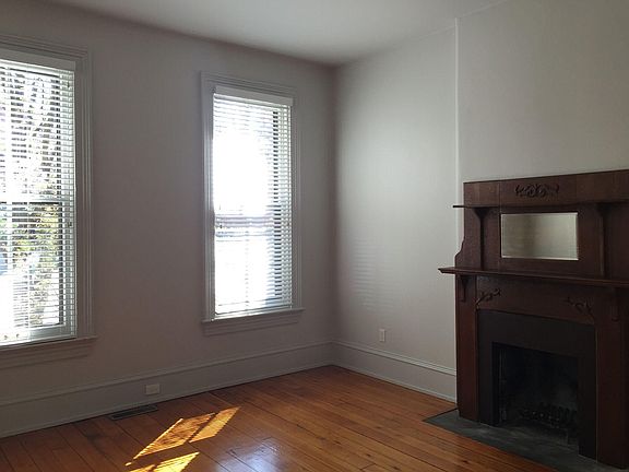 Turn of the Century fireplace and large windows in living ro
