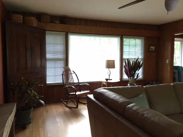 Living room looking out toward the front yard. Wood floors in living room, dining room, hallway, and bedrooms.