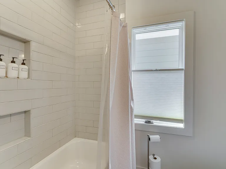 Private ensuite bathroom featuring a shower/tub combination, Italian soft-close cabinetry, and stocked with plush towels, hand soap, shampoo, conditioner, and body wash for your convenience.