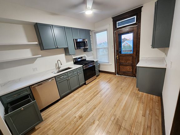 Sleek custom cabinetry, quartz-style countertops, and a built-in pull-out double trash bin.