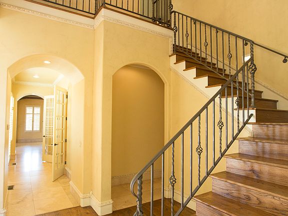 Gorgeous hand scraped hardwoods welcome visitors into the 2 story Entry boasting elegant chandelier, extensive crown moulding and arched detailing.