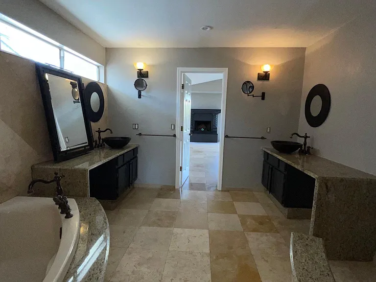 UNFURNISHED. Master bathroom, two separate vanities, bathtub. Granite countertops and bow sinks.