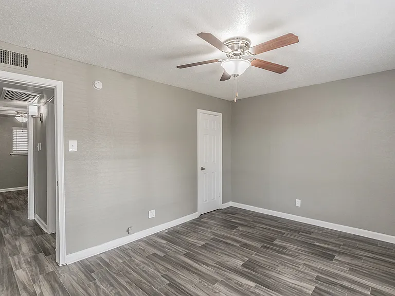 Bedrooms feature neutral finishes, ceiling fans, and ample natural light at Chapel Creek Apartments.