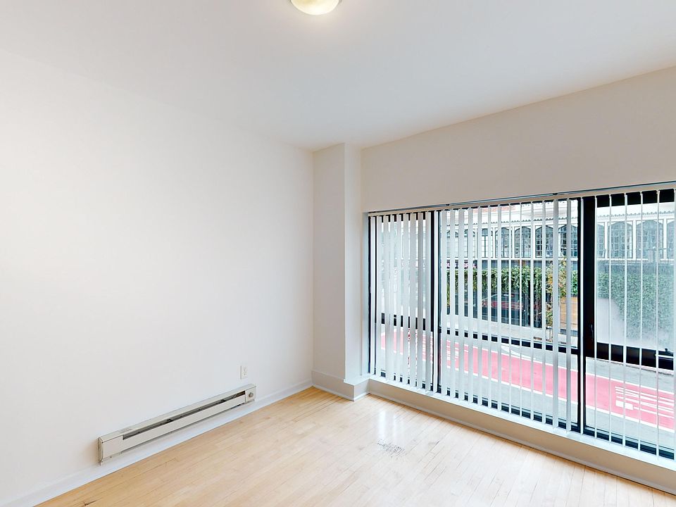 Spacious room with wood-like flooring and a large window offering natural light