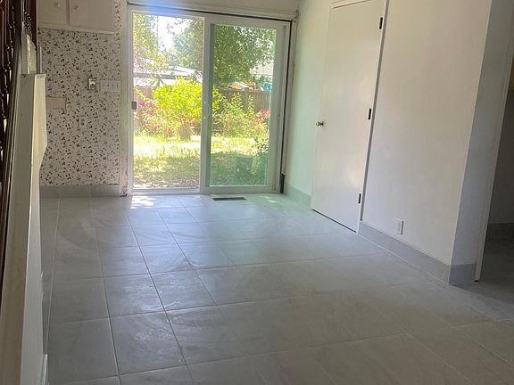 Newly tiled white granite KITCHEN AND LAUNDRY TO THE RIGHT SIDE
New sliding glass door to garden with fruit trees and roses, totally newly painted