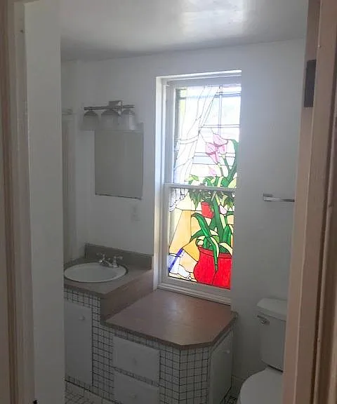 Bathroom with custom stainglass and custom granite vanity. (with bath/shower combo)